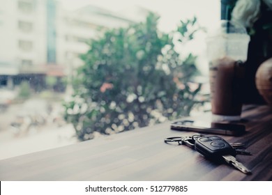 Key smartphone and ice coffee in cafe.Hi-key picture and soft focus for background.