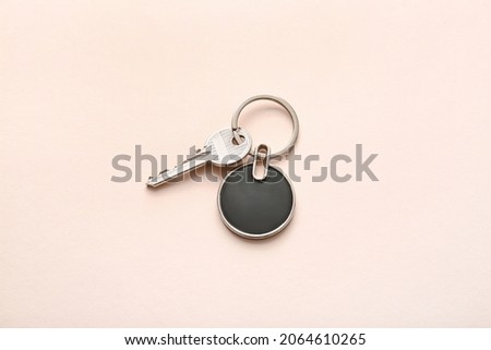 Key with stylish keychain on light background