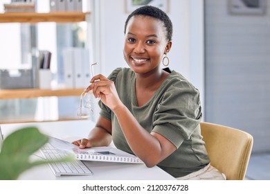 The key to success starts with how you define it. Portrait of an african businesswoman smiling while sitting at her desk. - Shutterstock ID 2120376728