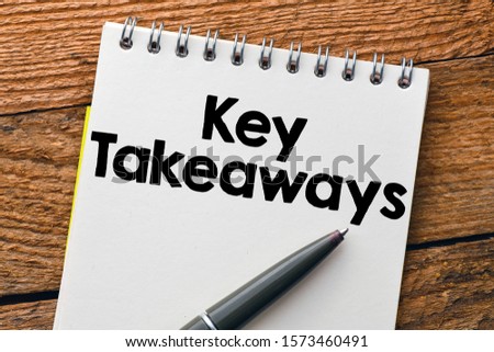 Key Takeaways. Text written in a notebook on a wooden background. View from above.