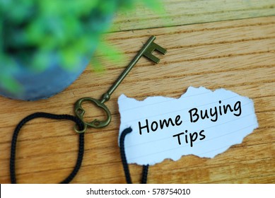 Key And Torn Paper With Text Home Buying Tips On Wooden Background