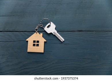 Key with trinket in shape of house on table
