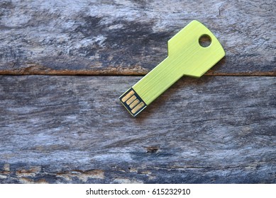 Key USB data storage isolated on wooden background