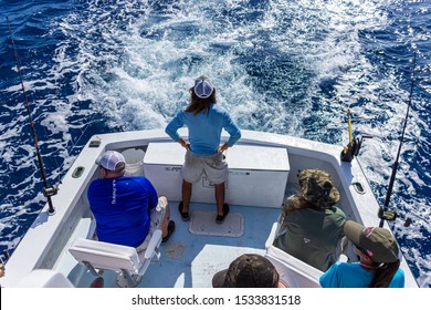 Key West, FL / USA - October 9, 2019: Keaton Cook, First Mate on the charter fishing boat "Reef Runner," checks the rigging on the boat while trolling for sailfish in the Atlantic Ocean.