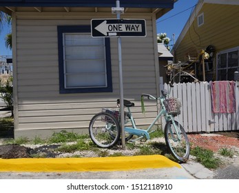 Key West, Florida-August 2019: One Of The Old Houses With A Bike Tied To A Street Sign In Key West, Florida.