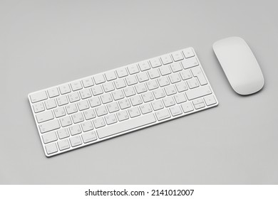 Keyboard and computer mouse isolated on a light gray background.