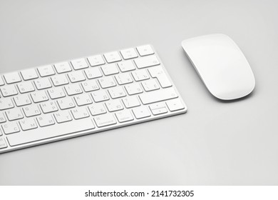 Keyboard and computer mouse isolated on a light gray background.
