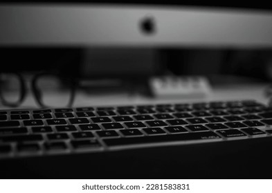 keyboard and glasses and iMac computer in background 