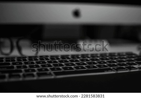 keyboard and glasses and iMac computer in background 