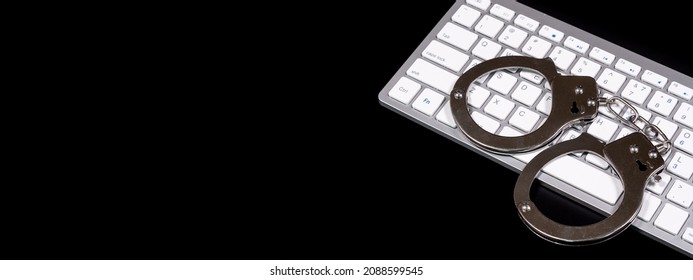 Keyboard And Handcuffs With LED Lights On. Cybercrime Concept.