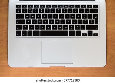 A keyboard of a laptop computer on a wooden table