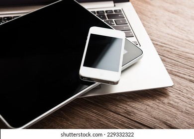 Keyboard With Phone And Tablet Pc On Wooden Desk 