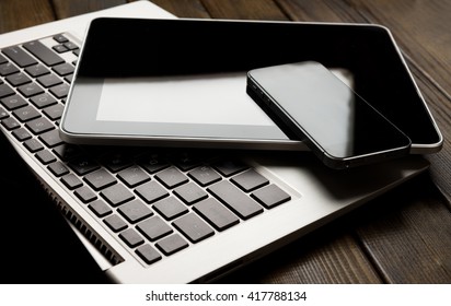 keyboard with phone and tablet pc on wooden desk 