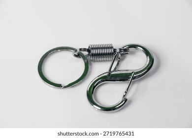 keychain featuring a split ring connected to a spring-loaded carabiner clip with green accents, displayed against a plain white background.