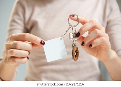 Keychain Mockup To Display Design. Key Chain Mock Up In Woman Hand With Apartment Keys. Blank Rhombus White Sublimation Key Chain Photo.