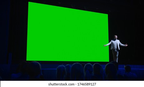 Keynote Speaker Announces New Product To The Audience, Behind Him Movie Theater With Green Screen, Mock-up, Chroma Key. Business Conference Live Event Or Device Reveal