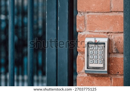 Keypad access control system mounted on a red brick wall, protecting home or business entrance with security code