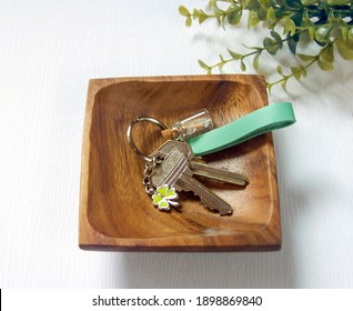 Keys attached to leather keychain on wood plate