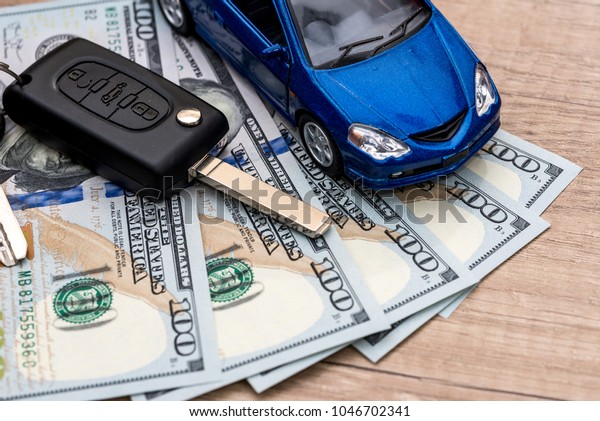 Keys\
to the car, dollars and the car that lie on the\
desk