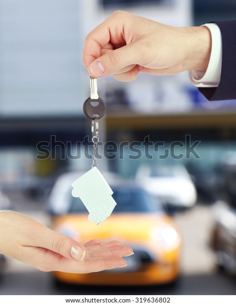 Keys in hand on\
blurred background store