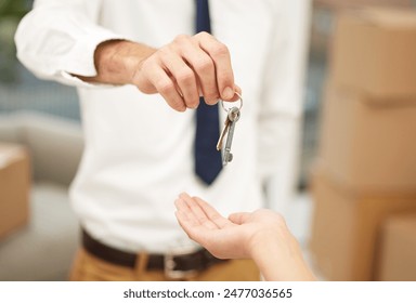 Keys, hands and real estate agent with client for mortgage, property investment or new house. Moving, boxes and man realtor with homeowner customer for apartment purchase, sale or agreement for rent. - Powered by Shutterstock