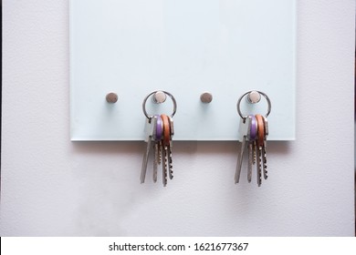 Keys hanging on modern open key box for storage keys on white wall closeup - Powered by Shutterstock