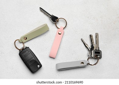 Keys with leather keychains on light background