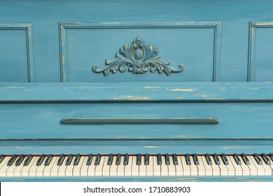 Keys of an old piano. Details of the design of the recolored blue and gold piano. Stucco on the piano