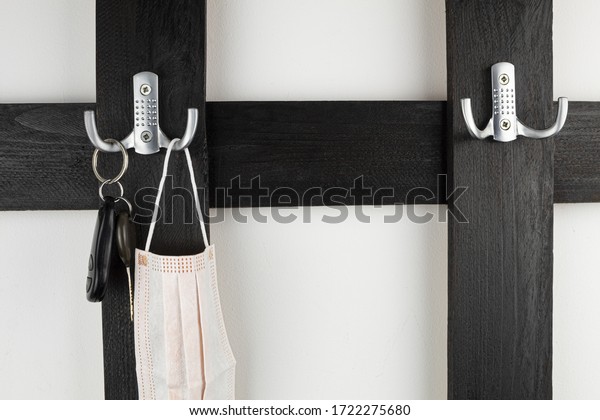 Keys on a hanger from a car and apartment. Keys\
hang on a wooden, black\
hanger