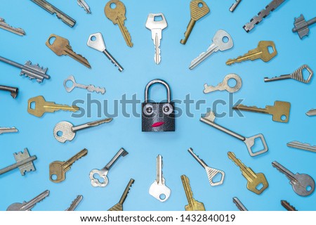 Keys set with funny lock concept, blue background. Choosing the best security system for home and business. Door lock keys and safes for property security and house protection.