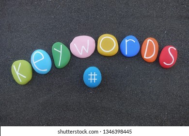 Keyword concept composed with multi colored stones over black volcanic sand
