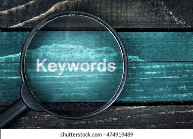 Keywords text painted and magnifying glass on wooden table