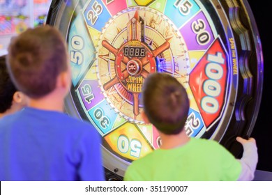 KFAR SABA, ISRAEL - DEC. 12, 2015: 8 Year Old Kids Having Fun At The Arcade With Video Games, Lottery Machines, Tickets, And Prizes.