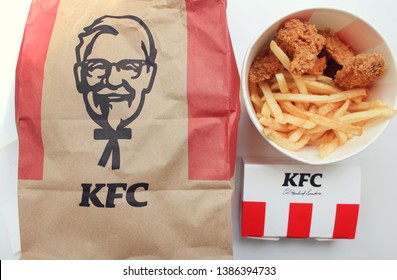 KFC fast food meal of classic Kentucky Fried Chicken bucket with wings and french fries with take out bag in Moscow, Russia on April 27, 2019 