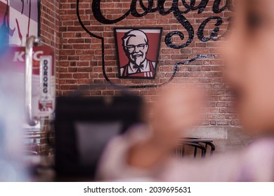 KFC logo or brand is a picture of Colonel Sanders on the wall of the fast food restaurant.