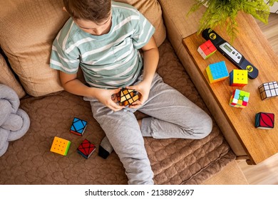 Khabarovsk, Russia - 18 02 2022: Male teenager boy confidentl assembling Rubik's cube mirror mill brainstorming making logic solution. Adolescent kid thinking connect colored bricks