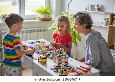 Khabarovsk, Russia, August 25, 2022. Enthusiastic Children With Mom Constructing Toy Cars, House Use Lego Classic At Home. Cute Family Playing Constructor Pieces Building Vehicle Toy