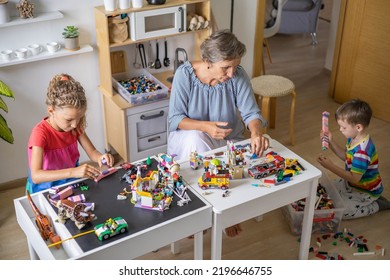 Khabarovsk, Russia, August 25, 2022. Enthusiastic Children With Mom Constructing Toy Cars, House Use Lego Classic At Home. Cute Family Playing Constructor Pieces Building Vehicle Toy