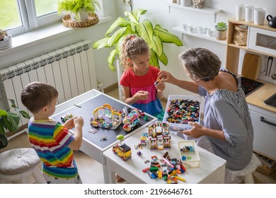 Khabarovsk, Russia, August 25, 2022. Enthusiastic Children With Mom Constructing Toy Cars, House Use Lego Classic At Home. Cute Family Playing Constructor Pieces Building Vehicle Toy