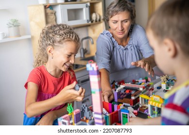 Khabarovsk, Russia, August 25, 2022. Enthusiastic Children With Mom Constructing Toy Cars, House Use Lego Classic At Home. Cute Family Playing Constructor Pieces Building Vehicle Toy