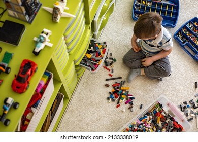 Khabarovsk, Russia, February 18, 2022. Cute Boy Sorting Lego Into Boxes With Cells. Children's Room With Constructor Details Vertical Storage System. Male Kid Neatly Folded Pieces Home Cleanup