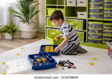 Khabarovsk, Russia, February 18, 2022. Cute Boy Sorting Lego Into Boxes With Cells. Children's Room With Constructor Details Vertical Storage System. Male Kid Neatly Folded Pieces Home Cleanup