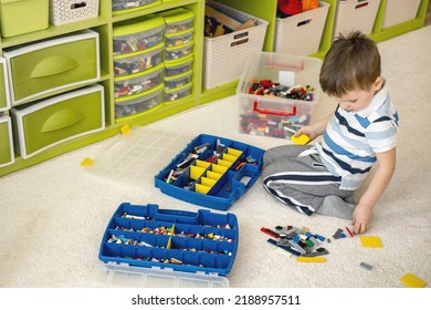 Khabarovsk, Russia, February 18, 2022. Boy Sorting Lego Colored Pieces Into Boxes With Small Cells. Constructor Toy Storage System, Home Cleanup. Male Kid Putting Blocks To Containers At Childish Room