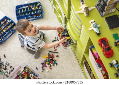 Khabarovsk, Russia, February 18, 2022. Cute Boy Sorting Lego Into Boxes With Cells. Children's Room With Constructor Details Vertical Storage System. Male Kid Neatly Folded Pieces Home Cleanup