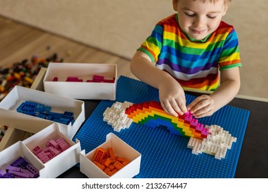 Khabarovsk, Russia, February 25, 2022. Confident Baby Boy Constructing Rainbow Use Lego Classic Multicolored Brick Closeup. Enthusiastic Male Kid Playing Constructor Pieces Building Development Toy