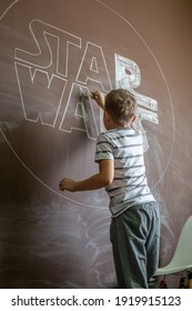 Khabarovsk, Russia, Janyary 10, 2021. The wall is painted with brown paint. The child draws and writes words on the wall. Star Wars concept.
