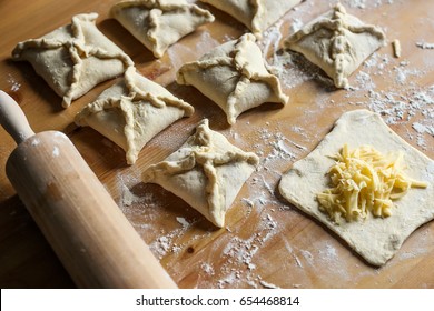 Khachapuri With Cheese Inside On A Wooden Background. Flour, Roll, Dough, Cheese. Cooking Khachapuri .Flour, Dough And Rolling Pin On The Table. Puff Pastry