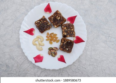 Khajur Ka Halwa Or Khajoor Paak Is A Traditional Indian And Pakistani Dish. Dry Fruit Halwa Barfi Dates Decorated With Red Pink Rose Petals And Served During Winter Season Festival Like Uttarayan