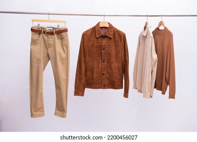 Khaki Pants And Sweaters With Shirt, And Jacket On Hanging On The White Background