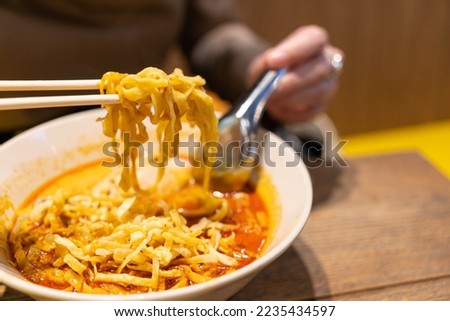 Khao Soi, Thai Noodles Khao Soi, Chicken Curry with seasoning on wooden floor, Northern Thai food concept. Northern Thai Curry Noodles with Chicken